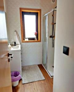 a bathroom with a shower and a sink and a window at Perfect Mountain Lodge with Pool in Fafião