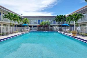 a swimming pool in front of a building at Motel 6 Dania Beach in Dania Beach