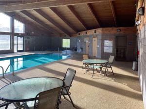 a swimming pool with tables and chairs in a building at Motel 6 Norway MI in Norway
