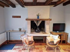 - un salon avec une cheminée et 2 chaises dans l'établissement Git'Albert a 10 minute du château royale de Chambord, à Mont-près-Chambord