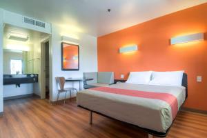 パーム・スプリングスにあるモーテル6 パームスプリングス ダウンタウンのベッドと机と洗面台のある寝室