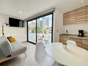 a kitchen and living room with a white table and chairs at Second Home Darwin in Mexico City