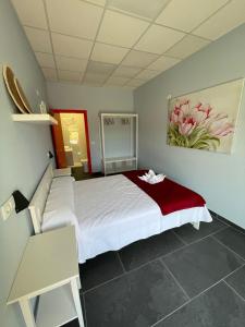 a bedroom with a bed and a painting on the wall at Hostel & Rooms O Albergue da Meiga in Padrón