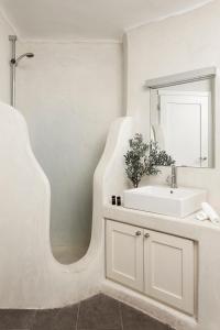 ein weißes Badezimmer mit Waschbecken und Spiegel in der Unterkunft Newly built spectacular Sunset villa at St. John, Mykonos in Mykonos Stadt