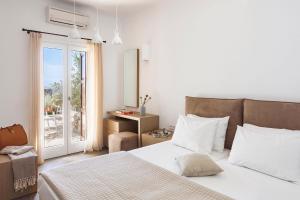 ein Schlafzimmer mit einem Bett und einer Tür zu einer Terrasse in der Unterkunft Newly built spectacular Sunset villa at St. John, Mykonos in Mykonos Stadt + 95 Fotos