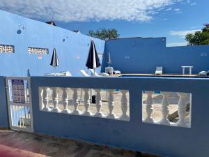 pared azul con balcón con sombrillas en Hotel Sirena, en Praia Grande