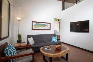 ein Wohnzimmer mit einem Sofa und einem Tisch in der Unterkunft Casa Henaway - Portasol Vacation in Savegre