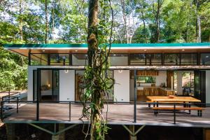 ein Haus im Wald mit einem Baum in der Unterkunft Casa Henaway - Portasol Vacation in Savegre