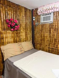 ein Schlafzimmer mit einem Bett und rosa Rosen an der Wand in der Unterkunft Moonlight's Inn in General Luna
