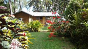 a house in the middle of a garden with flowers at Amuri Sands in Arutanga