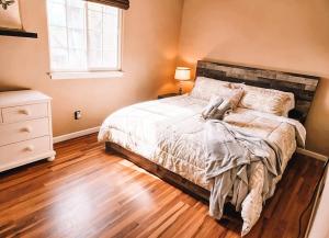 een slaapkamer met een bed en een houten vloer bij Pet Friendly 2 King Beds AF Academy Sleeps 12 in Colorado Springs