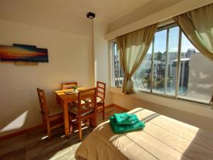1 dormitorio con cama, escritorio y ventana en Mountain Center en San Carlos de Bariloche