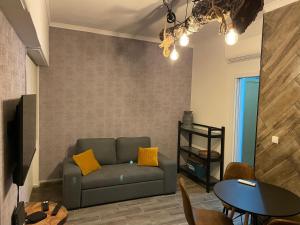 uma sala de estar com um sofá e uma mesa em Ambientes do Rio Home em Sacavém