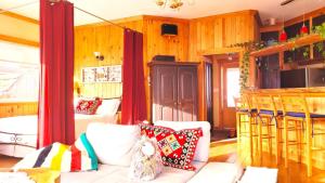 a living room with a white couch and wooden walls at La vieille ferme, Écogîte in Saint-Fulgence