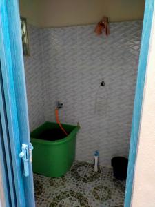 La salle de bains est pourvue d'une baignoire verte et d'une douche. dans l'établissement Alor Setar Homestay, à Kuala Kedah