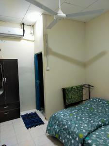 Schlafzimmer mit einem Bett und einem Deckenventilator in der Unterkunft Alor Setar Homestay in Kuala Kedah