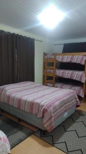 a bedroom with two bunk beds in a room at Cantinho aconchegante in Campos do Jordão
