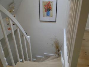 a white staircase with a picture of flowers on the wall at Ferienwohnung Back in Rantum