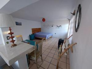 a living room with a table and a bedroom at Casa Nopal Tu casa vacacional tipo hotel in Creel