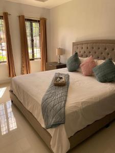 a bedroom with a bed with a teddy bear on it at Luxurious Villa Royale- 5 min drive to Ocho Rios in Ocho Rios