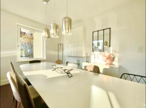 een witte eetkamer met een witte tafel en stoelen bij Charmante maison - centre-ville Colmar in Colmar