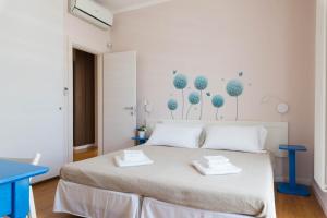 a white bedroom with a bed with two towels on it at Casa Torre di Specchio 2 con Piscina in Bari