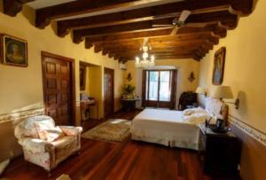 een slaapkamer met een bed en een stoel in een kamer bij Casa Laurel Oaxaca in Oaxaca City