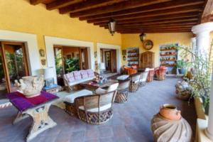 een woonkamer met veel stoelen en tafels bij Casa Laurel Oaxaca in Oaxaca City