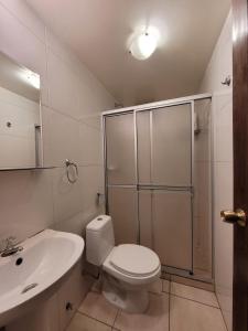 a bathroom with a toilet and a shower and a sink at Hotel Nuevo Sol in La Paz