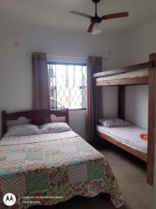 a bedroom with two bunk beds and a window at Casa de Praia em Barra Velha Itajuba SC por Temporada in Barra Velha