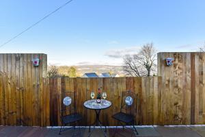 a table with two chairs in front of a fence at La Cantera in Merthyr Tydfil