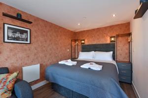 a bedroom with a bed with two towels on it at La Cantera in Merthyr Tydfil