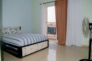 a bedroom with a bed and a window with a view at Comfortable and Cozy Apartments in Praia