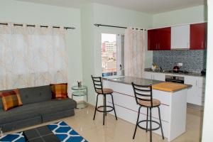 una cucina e un soggiorno con divano e bar di Comfortable and Cozy Apartments a Praia