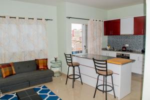 a kitchen and living room with a couch and a bar at Comfortable and Cozy Apartments in Praia