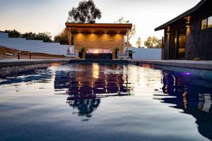 a pool of water with a house in the background at Luxury Desert Retreat w Pool & Jacuzzi in Joshua Tree