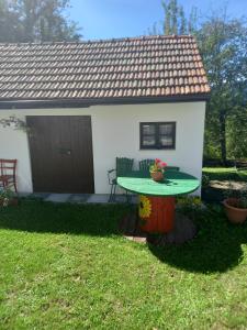 una pequeña casa con una mesa en el patio en Family friendly house with a parking space Zakrajc Brodski, Gorski kotar - 20569, en Brod na Kupi
