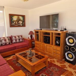 sala de estar con sofá y TV de pantalla plana en Condominio Altos de Mirasol II, en Algarrobo