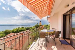 a balcony with a table and chairs and a view of the water at Apartments Nenad in Dramalj