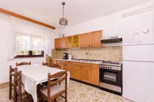 a kitchen with a table and a stove top oven at Apartments Nenad in Dramalj
