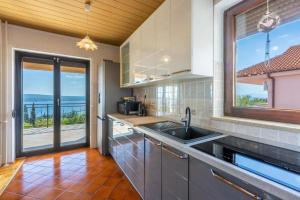 a kitchen with a sink and a view of the ocean at Apartment Klaudia in Dramalj