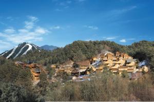 a group of houses on a hill with a snow covered mountain at Hyundai Soo Resort Hoengseong in Pyeongchang