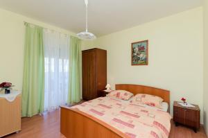 a bedroom with a large bed with pink pillows at Apartment Anica in Kampor
