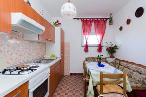a kitchen with a table and a stove top oven at Apartment Anica in Kampor