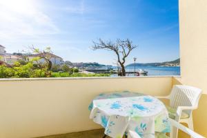 a table and chairs on a balcony with a view of the water at Apartments Darko by the sea in Supetarska Draga