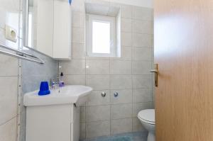 uma casa de banho com um lavatório, um WC e uma janela. em Apartments Darko by the sea em Supetarska Draga