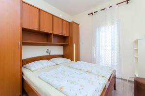 1 dormitorio con 1 cama grande y armarios de madera en Apartments Darko by the sea en Supetarska Draga