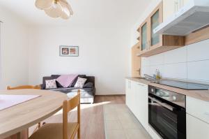 eine Küche und ein Esszimmer mit einem Tisch und einer Couch in der Unterkunft Apartments Darko by the sea in Supetarska Draga
