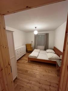 een slaapkamer met een bed en een stoel erin bij Broockhof Ferienwohnung unterm Sternenhimmel in Mecklenburg in Reimershagen
