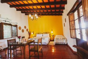 a bedroom with two beds and a table and chairs at Finca Las Margaritas in Chicoana